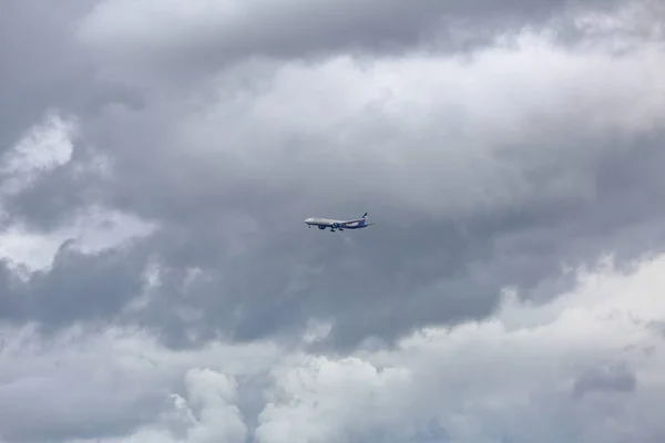 Aviones de pasajeros en el cielo gris nublado — Foto de Stock