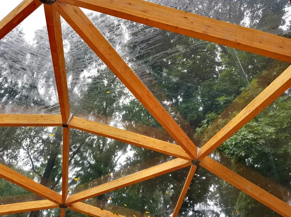 Telhado de madeira com celofane sob a chuva de verão — Fotografia de Stock