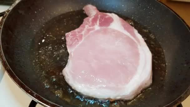 オリーブオイルでフライパンで揚げた脂肪豚の骨にジューシーな食欲をそそるステーキ — ストック動画