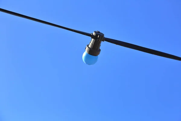 Gekleurde straatlamp zonder lampenkap op een draad — Stockfoto