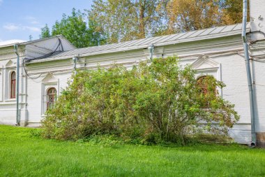 Yaz günü şehir parkındaki eski beyaz tuğla bina.