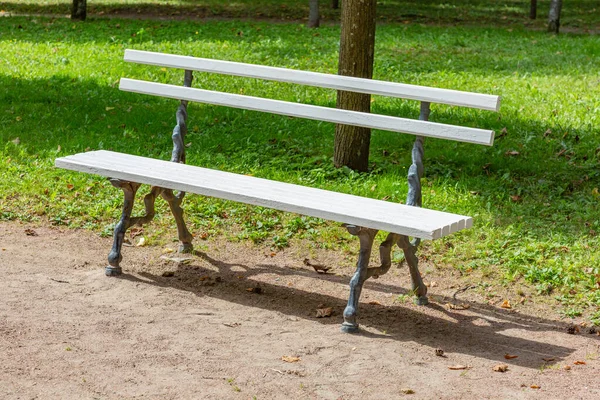 夏季公园里的一条由白色木板和锻铁制成的休闲长椅 — 图库照片