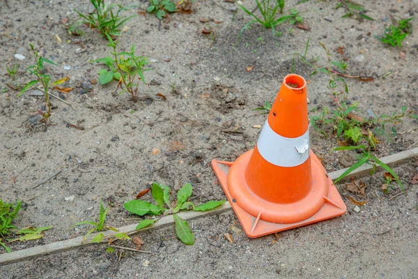 Plastic orange cone shaped road sign warns of danger