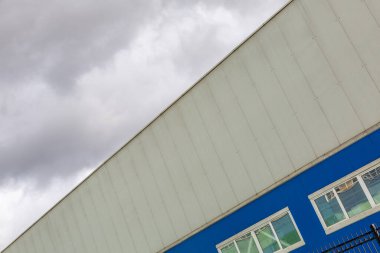 Endüstriyel veya depo kullanımı için panel binası dramatik bir gökyüzünün arka planına karşı