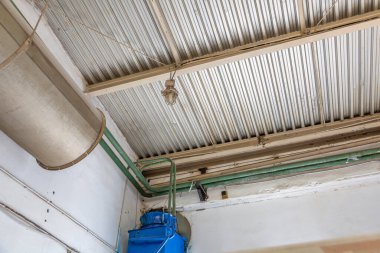 Sanayi fabrikasının atölyesindeki eski alüminyum panellerden yapılmış tavan.