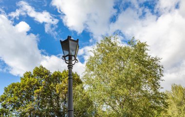 Halka açık bir parkta antika siyah bir fener.