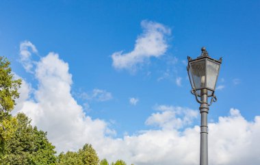 Halka açık bir parkta antika siyah bir fener.