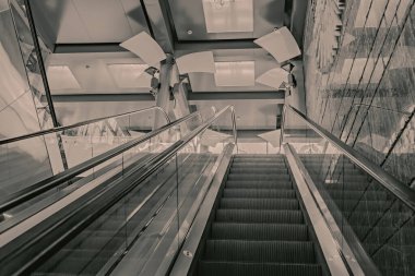 Modern bir alışveriş merkezinde insanları kaldırmak için geleceğin metal yürüyen merdiveni.