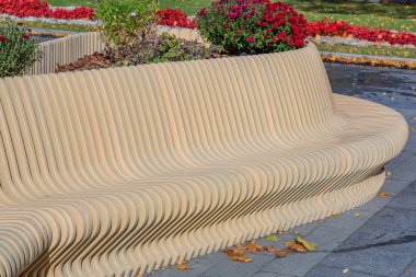 Sonbaharda bir şehir parkında tahtadan ve demirden yapılmış bir tezgah.