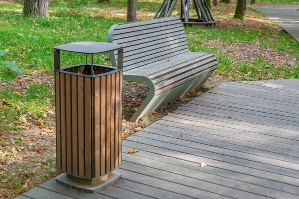 秋天在一个城市公园里用木板和锻铁做的休闲长椅 — 图库照片