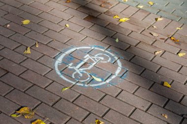 Beyaz boyalı bisiklet trafik levhası. Şehir taş kaldırımı