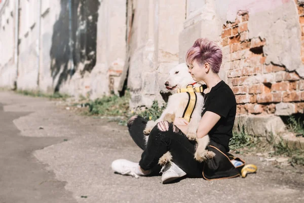 Junge moderne Frau und ihr lustiger weißer Welpe. Spaziergang mit Hund . — Stockfoto