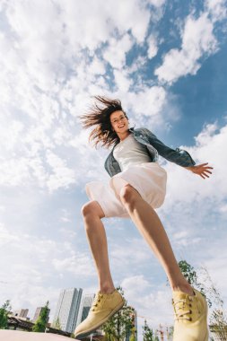 Güzel bir kadın yükseğe zıplar. Gökyüzüne doğru hızla uçuyor..