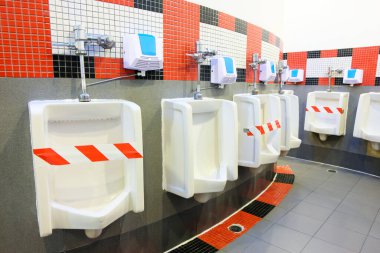 Corona virüsü salgını sırasında umumi erkekler tuvaleti. İnsanların virüsün yayılmasını önlemek ve korumak için sosyal mesafeyi korumaları gereken yeni bir normal. Kişisel hijyen, güvenlik ve sağlık konsepti.