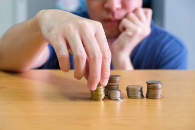 Asyalı erkeklerin seçici odak noktası el planlama ve para biriktirme. Kişisel mali veya tasarruf yönetimi kavramı, zenginlik ve daha fazla gelir,