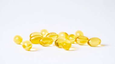 Beyaz arka planda sarı balık yağı takviyesi kapsülünün seçici odağı. İyi beslenmek için ilaç ve vitamin. Sağlık ve Tıp Konsepti.