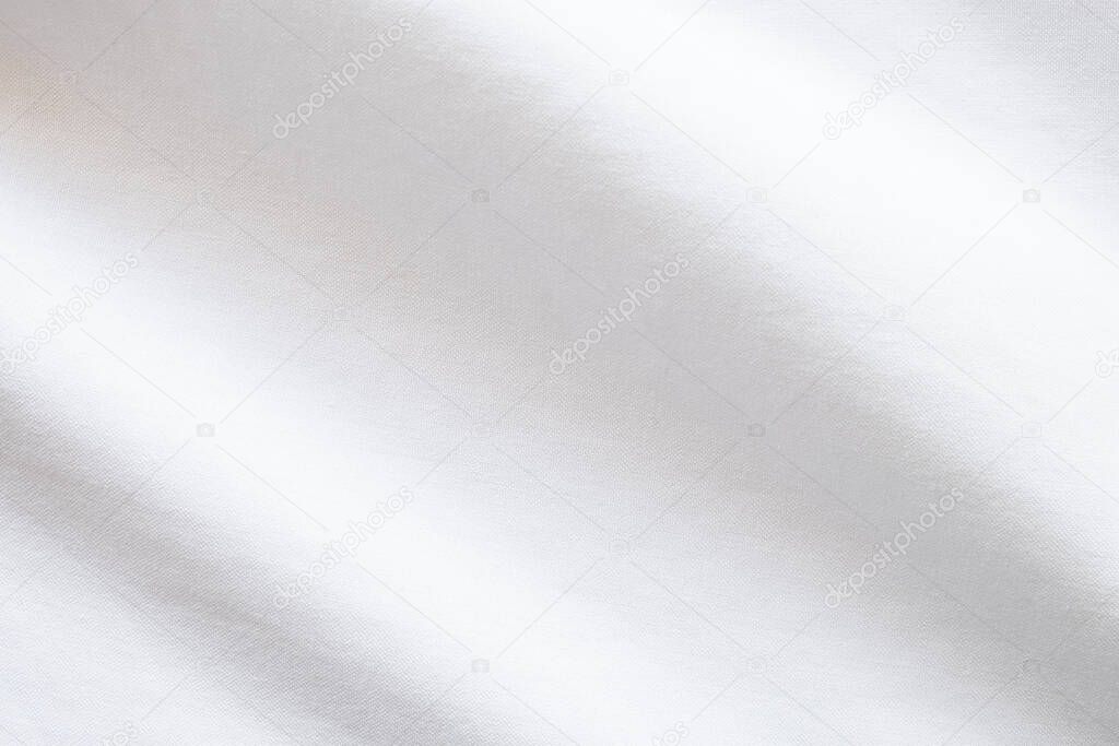 Top view close up shot of white fabric cotton shirt with woven gradient detail. Background and wallpaper concept.