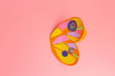 Kelebeğin kağıt kanatları, çocuk sanat projesi, pembe arka plan, üst görünüm