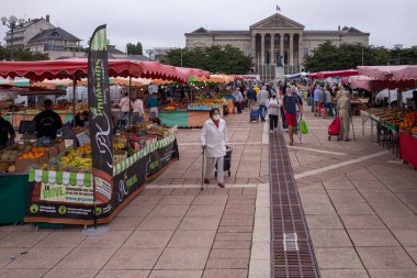 Fransa 'nın pazar yerinde alışveriş yaparken yüz maskesi takan farklı insanlar için açık havada maske takmak zorunludur.