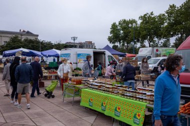 Fransa 'nın pazar yerinde alışveriş yaparken yüz maskesi takan insanlar açık havada maske takmak zorunludur.