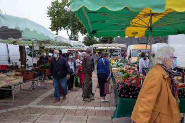 Fransa 'nın pazar yerinde alışveriş yaparken yüz maskesi takan insanlar için açık havada maske takmak zorunludur.