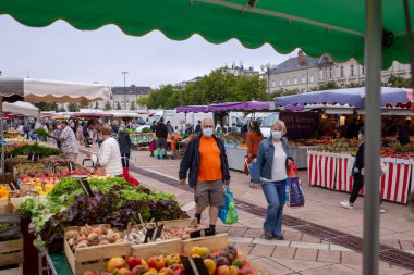 Fransa 'nın pazar yerinde alışveriş yaparken yüz maskesi takan yaşlılar için dışarıda maske takmak zorunludur.
