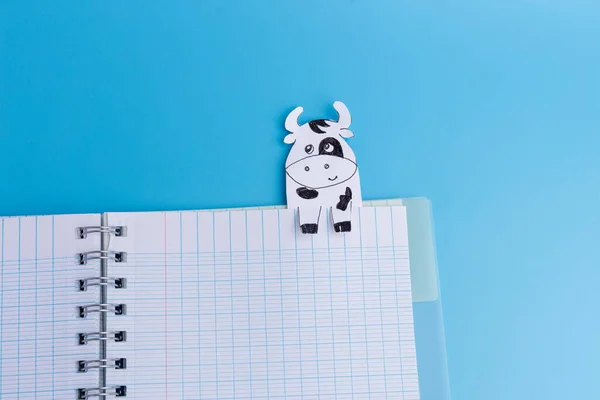 Livro aberto com marcadores de vaca no fundo azul — Fotografia de Stock