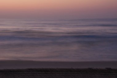 Güneş doğarken ıssız sahil kıyısı, uzun pozlama, ipek etkisi.