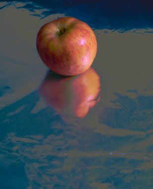 Elma gümüş zeminde, yansımalar, kırmızı