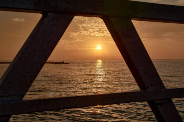 Солнце Встает Между Перилами Дорожки Море Оранжевый Картина — стоковое фото