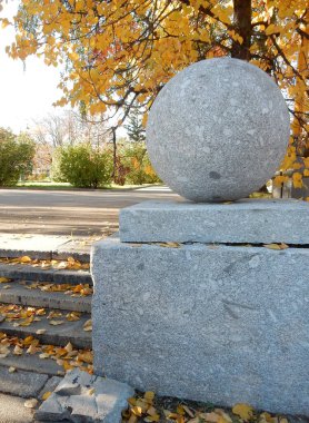 Sonbahar yeşillik arka planında heykel granit balosu, seçici odaklanma. Yüksek kalite fotoğraf