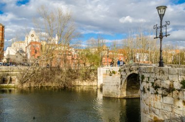 Palencia, İspanya - 26 Mart 2016: Kentsel peyzaj, Ortaçağ taş köprü görünümünü ve Gotik katedral (Kastilya ve Leon), Palencia, İspanya