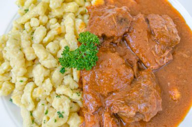 Et güveci ile spetzle, tipik Avusturya yemeği. Spaetzle, genellikle soslu et yemekleri için bir kenar olarak servis edilen düzensiz bir Orta Avrupa yumurta bazlı makarnadır.
