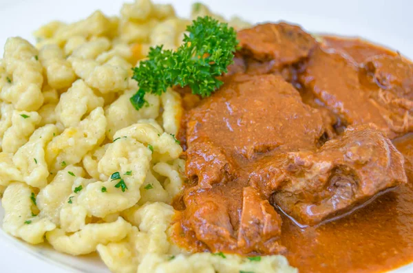 Et güveci ile spetzle, tipik Avusturya yemeği. Spaetzle, genellikle soslu et yemekleri için bir kenar olarak servis edilen düzensiz bir Orta Avrupa yumurta bazlı makarnadır.