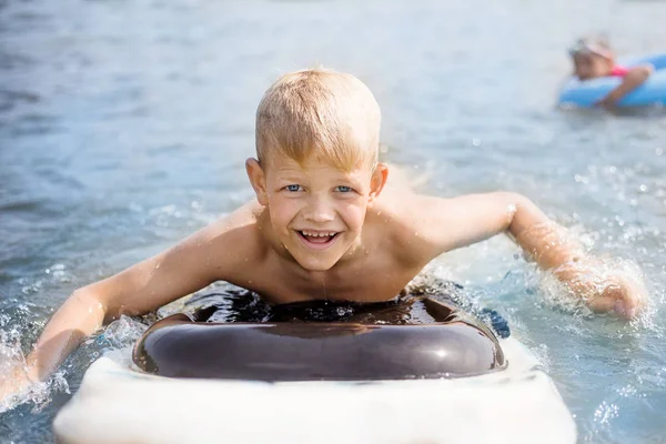 サーフボードを持つ小さな男の子は楽しんでいます 子供の頃の概念 — ストック写真