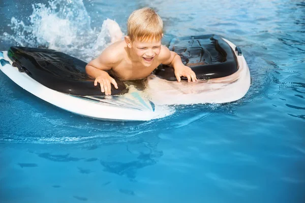 サーフボードを持つ小さな男の子は楽しんでいます 子供の頃の概念 ストックフォト