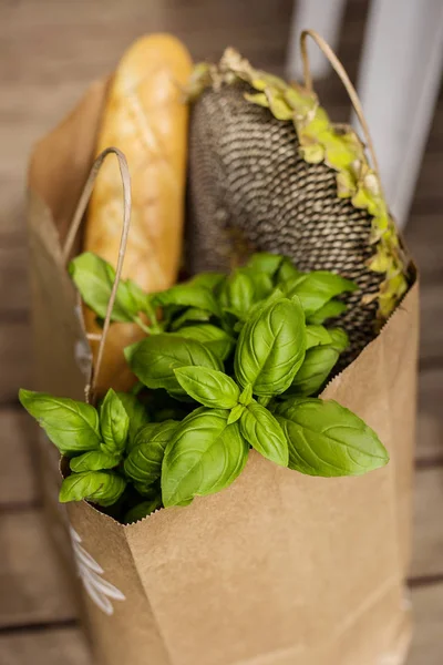 Various healthy food in paper bag on wooden background. Healthy food from the store