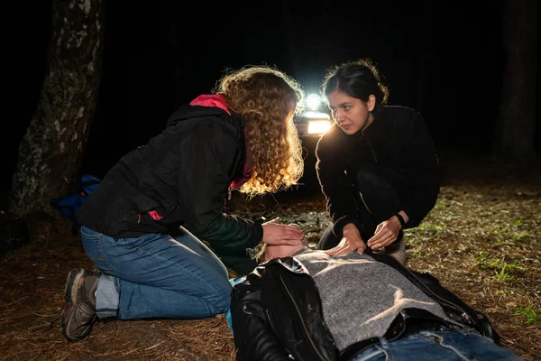 Fältutbildning Första Hjälpen Två Kvinnor Hjälper Man Som Ligger Marken — Stockfoto