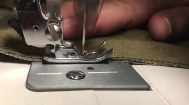 Terzi kumaş dikiş makinesi üzerine diker. İğne bir iş parçacığında kaba kumaş pembe. 