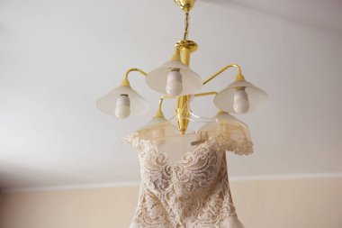 Gelinin elbise bir askı üzerinde asılı.