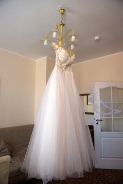 Gelinin elbise bir askı üzerinde asılı.