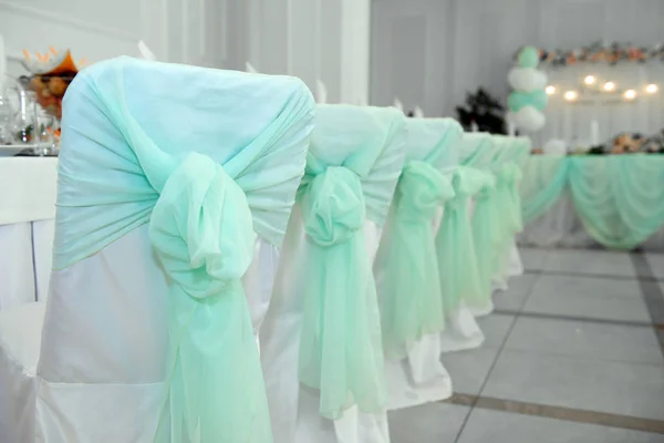 Wedding chairs in turquoise bows. — Stock Photo, Image