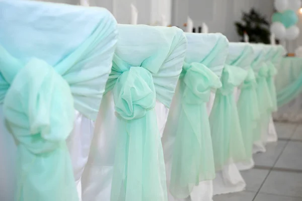 Wedding chairs in turquoise bows. — Stock Photo, Image