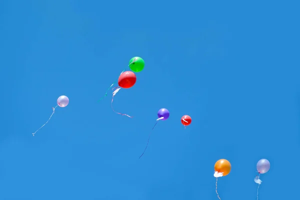 Bunte Luftballons fliegen in den blauen Himmel. — Stockfoto