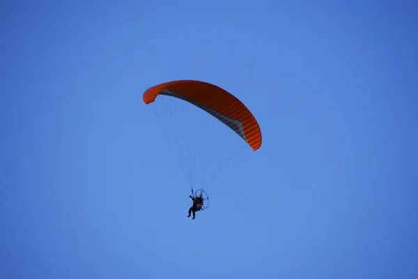 Paraglider flies in stormy skies. Stock Image