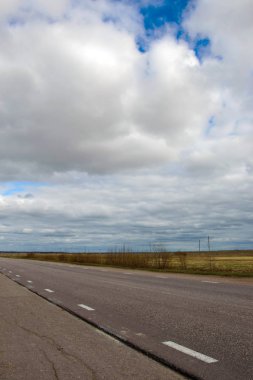 Manzara mavi gökyüzü ve büyük kabarık bulutlar.