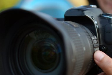 Fotoğraf makinesi DSLR fotoğrafçının eline bağlı objektif.
