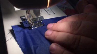 Kişi dikiş makinesinde kumaş dikiş. Kumaş üzerinde iplik cratches.