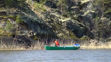 Karelia 'da bir teknede bir balıkçı.