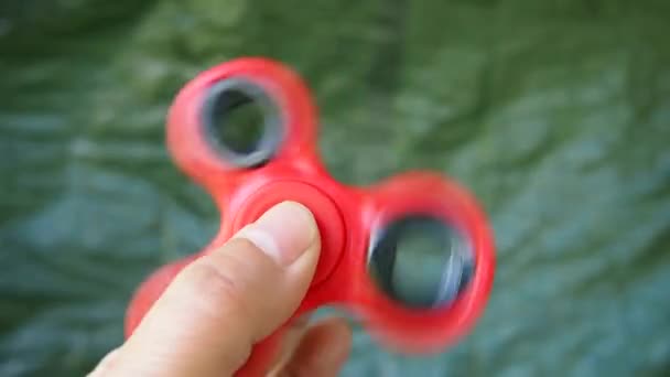 Pinwheel fidget spinner red color in the hands. — Stock Video